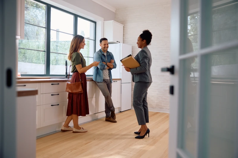 Happy couple talking to real estate agent